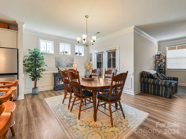 dining room featuring light hardwood / wood-style floors, ornamental molding, and a chandelier