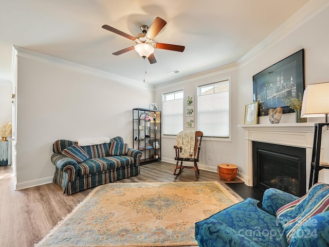 living room featuring crown molding, wood-type flooring, and ceiling fan