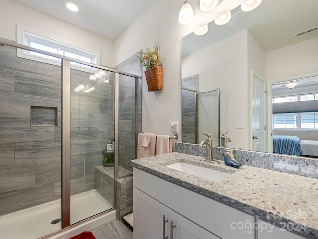 bathroom featuring a wealth of natural light, vanity, and a shower with shower door