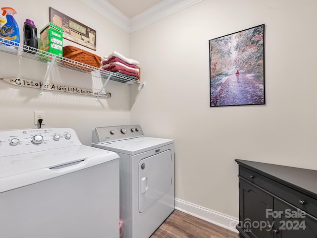 laundry room featuring washer and dryer, crown molding, cabinets, and dark hardwood / wood-style floors