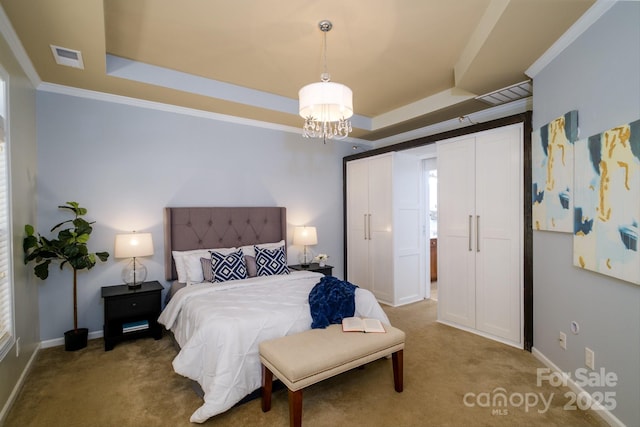 bedroom featuring a tray ceiling, carpet flooring, an inviting chandelier, and ornamental molding