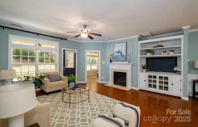 living room featuring wood-type flooring, ceiling fan, and ornamental molding