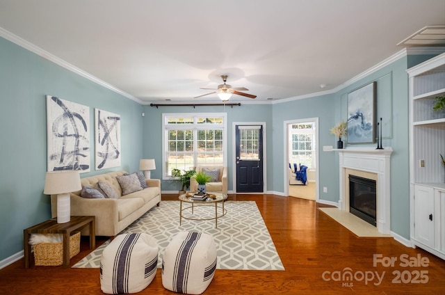 living room featuring hardwood / wood-style floors, ceiling fan, and ornamental molding