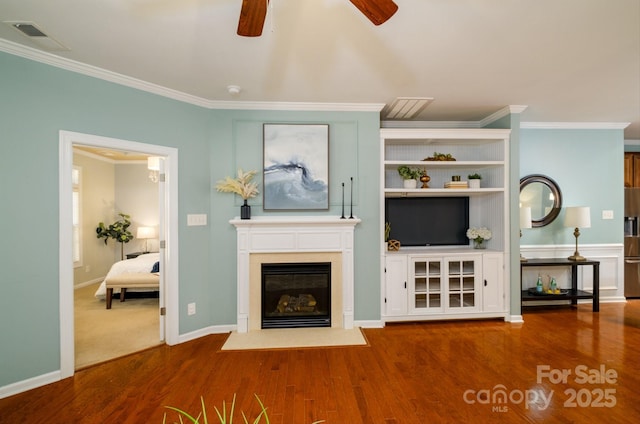 unfurnished living room with hardwood / wood-style floors, ceiling fan, and crown molding