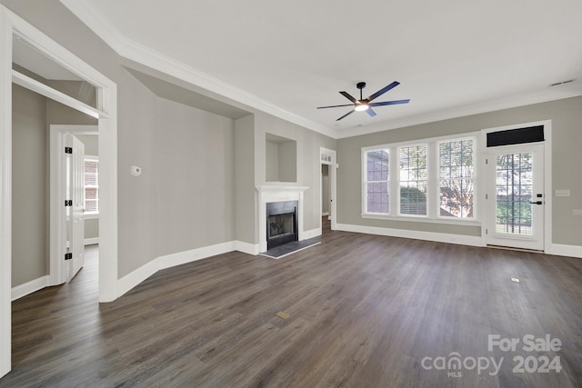 unfurnished living room with crown molding, ceiling fan, dark wood-type flooring, and a wealth of natural light