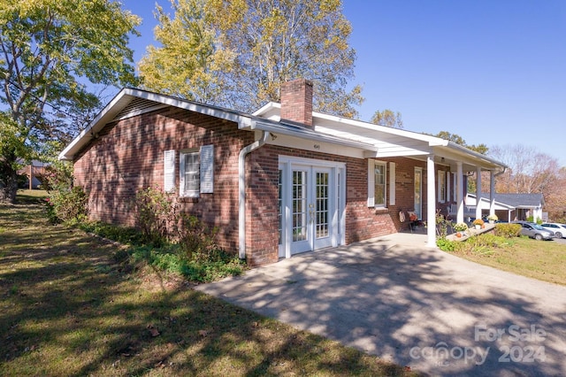 back of property featuring french doors and a yard