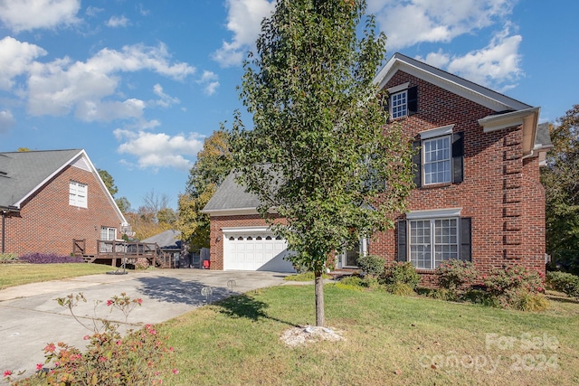 view of front of house featuring a wooden deck, a front lawn, and a garage