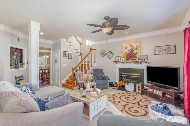 living room with ornate columns, ornamental molding, and ceiling fan with notable chandelier