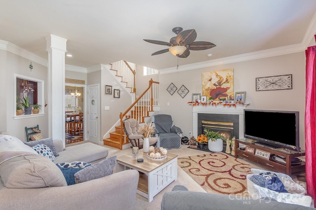 living room with ornate columns, ornamental molding, and ceiling fan with notable chandelier