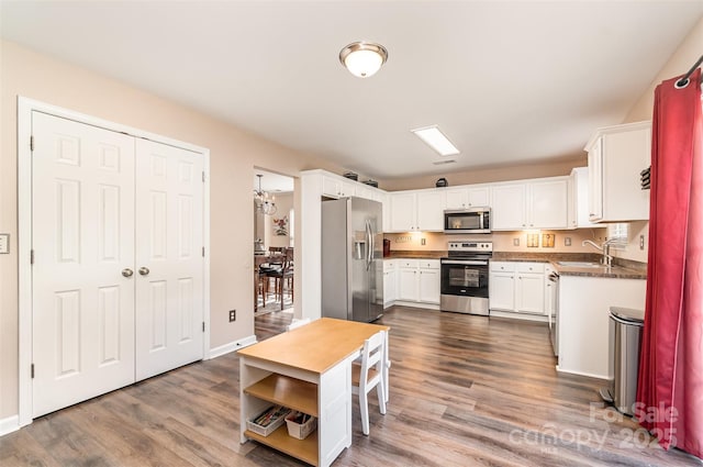 kitchen with white cabinetry, appliances with stainless steel finishes, dark wood-type flooring, and sink