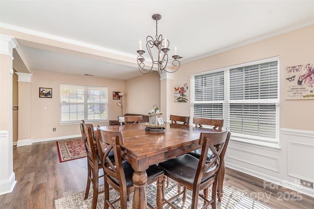 dining space featuring decorative columns, crown molding, dark hardwood / wood-style floors, and a chandelier