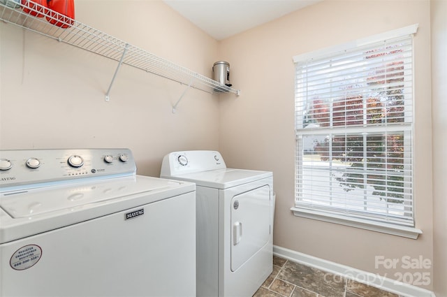 clothes washing area featuring a wealth of natural light and independent washer and dryer