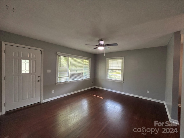 foyer with ceiling fan, a textured ceiling, and dark hardwood / wood-style flooring