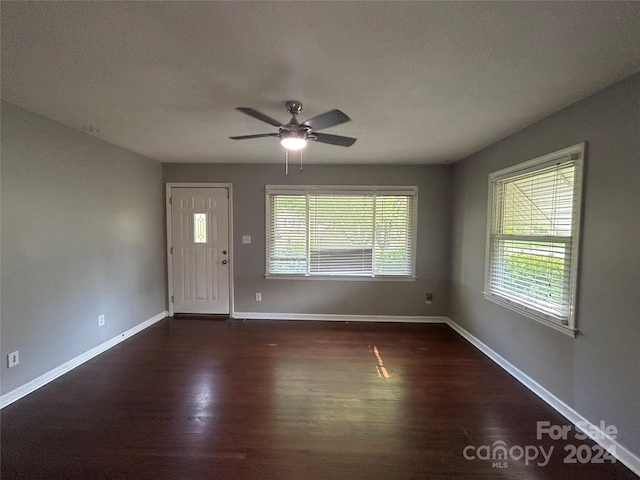 interior space with dark wood-type flooring, a textured ceiling, a healthy amount of sunlight, and ceiling fan