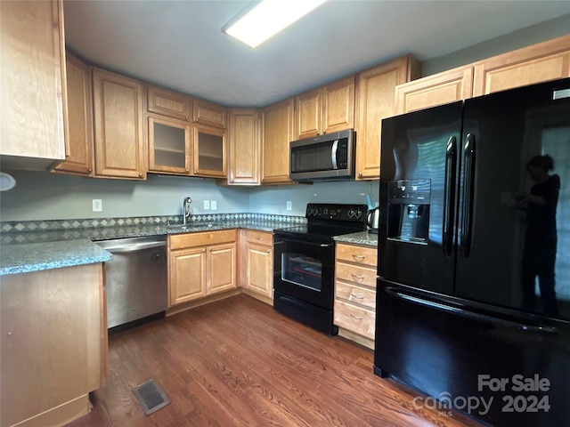 kitchen with light stone countertops, sink, black appliances, dark hardwood / wood-style flooring, and light brown cabinets