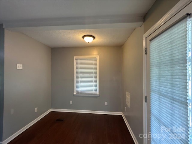 empty room with a textured ceiling and hardwood / wood-style floors