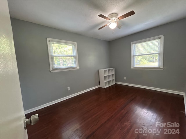 empty room with ceiling fan and dark hardwood / wood-style flooring