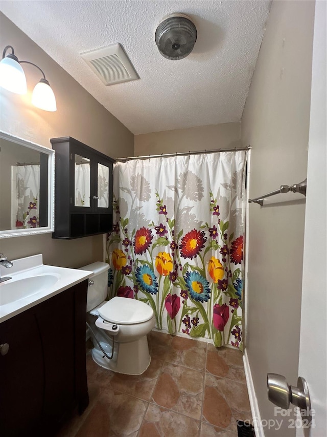 bathroom with vanity, toilet, a textured ceiling, and curtained shower