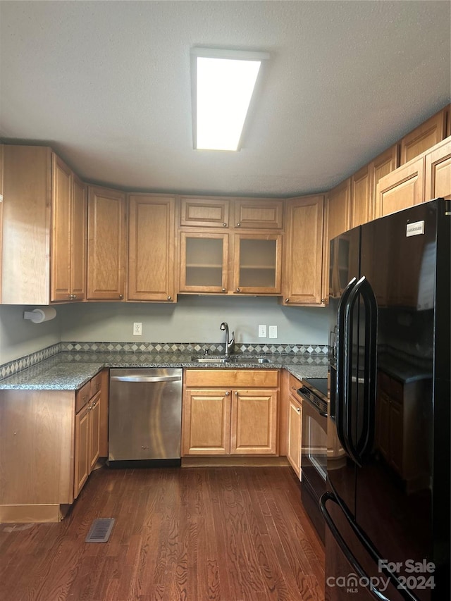 kitchen with dark wood-type flooring, a textured ceiling, black appliances, and sink