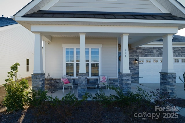 entrance to property with covered porch and a garage