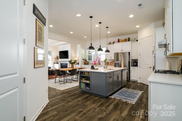 kitchen featuring white cabinetry, an island with sink, gray cabinetry, decorative light fixtures, and dark hardwood / wood-style flooring