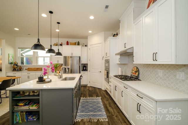 kitchen with pendant lighting, sink, white cabinetry, an island with sink, and stainless steel appliances