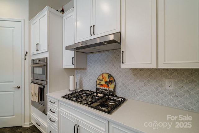 kitchen with stainless steel appliances, white cabinetry, and tasteful backsplash