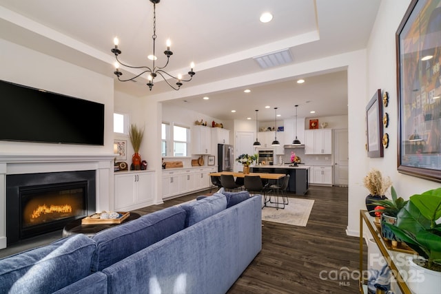 living room featuring dark wood-type flooring and an inviting chandelier