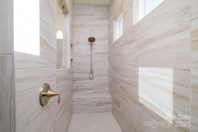 bathroom with plenty of natural light and tiled shower