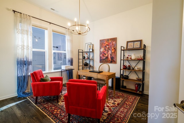 sitting room with dark wood-type flooring and a chandelier