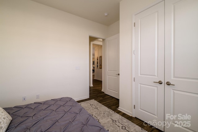 unfurnished bedroom with a closet and dark wood-type flooring