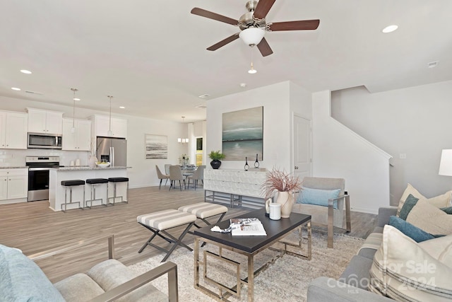 living room featuring light hardwood / wood-style flooring and ceiling fan