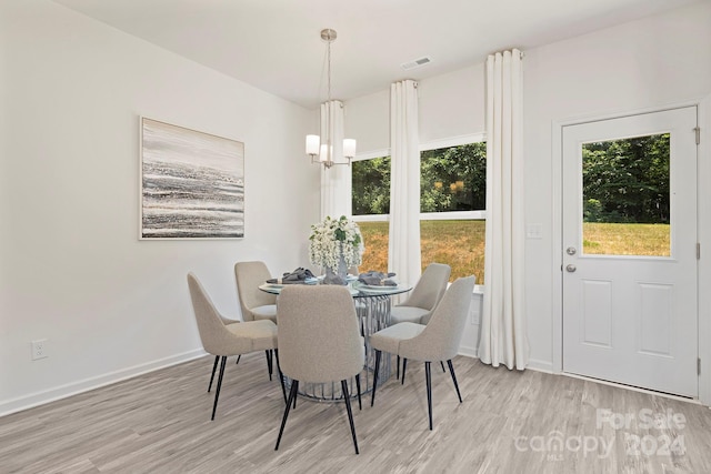 dining space featuring light hardwood / wood-style flooring and a chandelier