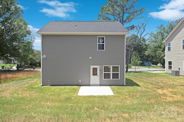 rear view of property featuring cooling unit and a yard