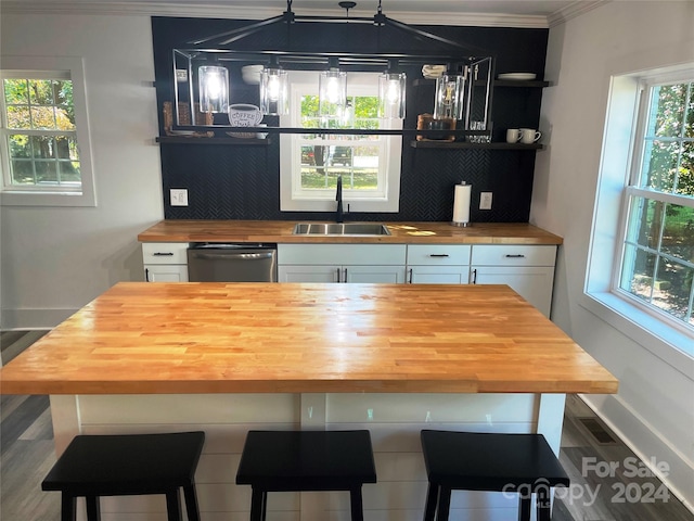 bar featuring wooden counters, ornamental molding, sink, and white cabinets