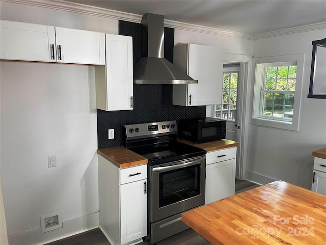 kitchen with white cabinets, stainless steel range with electric cooktop, backsplash, wall chimney exhaust hood, and butcher block countertops