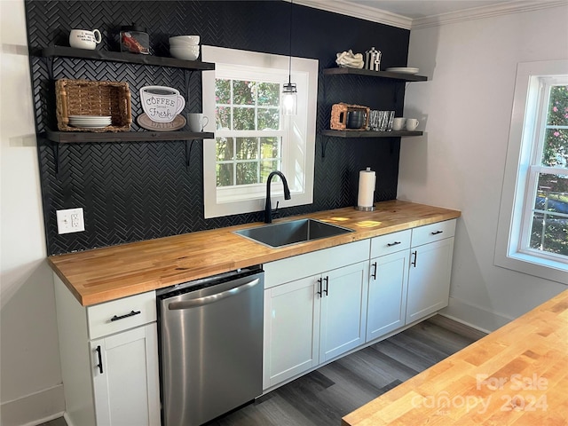 kitchen with dishwasher, sink, white cabinets, decorative light fixtures, and butcher block countertops