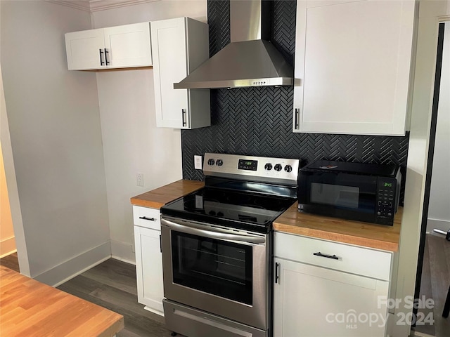 kitchen with wooden counters, wall chimney range hood, backsplash, stainless steel electric range, and white cabinets