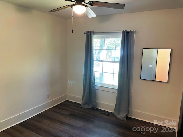 unfurnished room with dark wood-type flooring and ceiling fan