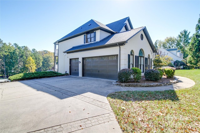 view of side of property featuring a yard and a garage