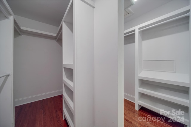 walk in closet with dark wood-type flooring