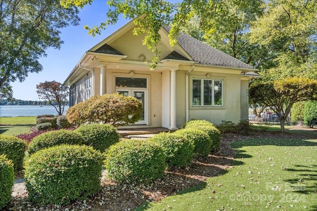 view of front of property with a front lawn and a water view