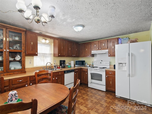 24 Palatka St, Arden, NC 28704 - kitchen featuring white appliances, under cabinet range hood, a sink, light countertops, and a chandelier