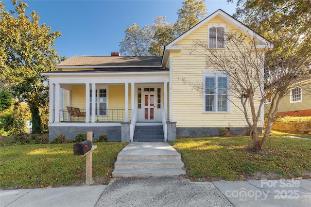 traditional-style house featuring a porch, a chimney, and a front lawn