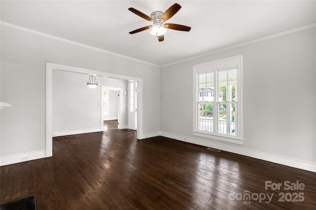 empty room with a ceiling fan, baseboards, ornamental molding, and dark wood-type flooring