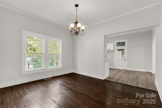 unfurnished dining area featuring crown molding, visible vents, dark wood-type flooring, a chandelier, and baseboards