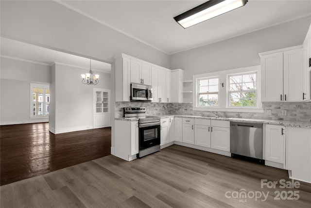 kitchen featuring stainless steel appliances, white cabinetry, hanging light fixtures, backsplash, and dark wood finished floors