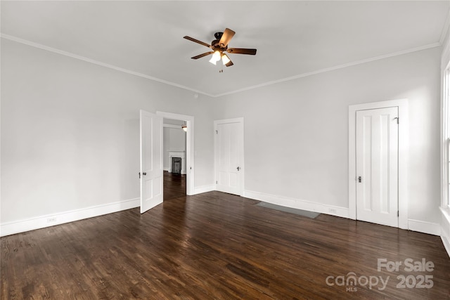 empty room with baseboards, ceiling fan, ornamental molding, and dark wood-style flooring