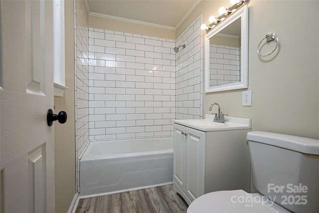 full bath with toilet, ornamental molding, wood finished floors, shower / bath combination, and vanity
