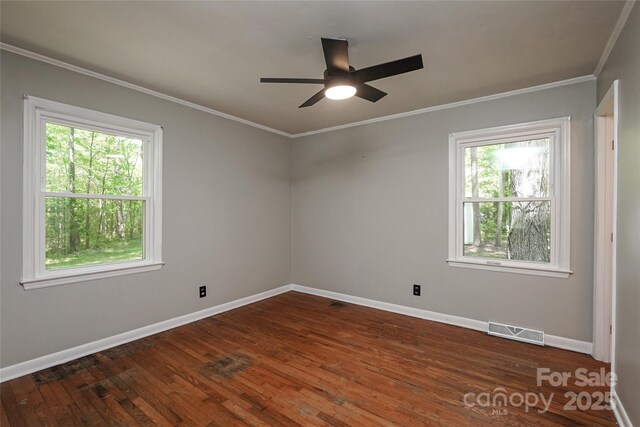 spare room with dark wood-style floors, baseboards, crown molding, and ceiling fan